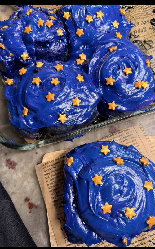 coraline inspired cinnamon rolls!! these were so fun to bake 💙🕷️ recipe: a quick note on the colors: i used a good amount of food coloring for these, including watkins no artificial food coloring and some of the wilton coloring. the colors in the video are NOT an accurate representation of how they looked in real life 😭 they were still super vibrant, but the dough was much more purple and the frosting colors were more distinct in person. if you want to avoid artificial dyes, there are natural alternatives you can experiment with, like blue spirulina mixed with black cocoa for darker shades of blue, or purple sweet potato powder for purple. the shades may vary though! dough 1 cup warm milk (240g) 1 tbsp active dry yeast (10g) ⅓ cup brown sugar (65–70g), divided 2 eggs ⅓ cup salted butter, melted (76g) 1 tbsp vanilla bean paste 3¾–4 cups bread flour (450–480g), 1 tsp salt purple and blue food coloring, as needed filling ½ cup salted butter, softened (113g) 1 cup brown sugar (200g) 2 tbsp cinnamon 7 oreos, crushed very finely 2 tbsp black cocoa powder 2 tbsp heavy cream cream cheese frosting 8 oz cream cheese, room temperature (226g) 4 tbsp salted butter, room temperature (57g) 1½ cups powdered sugar (180g), or to taste vanilla bean paste, to taste pinch of salt, optional blue, purple and black food coloring, as needed candy stars, for decorating instructions warm the milk and mix in 1 tbsp of the brown sugar. once it reaches about 110°F, stir in the yeast and let it bloom for 5 minutes. mix in the eggs, melted butter, remaining brown sugar, vanilla paste and food coloring. add the flour and salt, starting with 3 cups of flour and adding more as needed until you have a soft dough. knead until mostly smooth. the dough may feel a little tougher than usual with the food coloring, so don’t keep adding flour.  place in an oiled bowl, cover and let rise somewhere warm for about 1 hour, or until doubled in size. for the filling, mix the softened butter, brown sugar, cinnamon and finely crushed oreos. separately mix the black cocoa powder with the heavy cream until smooth, then mix it into the filling. add black food coloring if you want an even darker filling. punch down the risen dough and roll it into a rectangle. spread the filling evenly over the dough, cut into 8 strips and roll each strip individually. place the rolls into a parchment-lined 9x13-inch baking dish. let the rolls rest while the oven preheats to 350°F. pour about ⅓ cup heavy cream over the rolls just before baking. bake for approximately 30–45 minutes, checking earlier since ovens and roll sizes vary. if the tops start getting too dark before the centers are done, loosely tent with foil. make sure the centers are baked through. for the frosting, beat the cream cheese and butter until fluffy. mix in the powdered sugar, vanilla and optional pinch of salt. taste and adjust the sweetness to your liking. divide the frosting into about ⅔ blue and ⅓ purple. for the deep blue, i mixed mostly blue with a little purple and black. for the purple, i used purple and blue, with a tiny bit of burgundy if needed. i eyeballed all the coloring, so just keep adjusting until you get the shades you want! to get the two-tone swirl, lay plastic wrap flat and pipe the blue and purple frosting in two lines side by side. roll the plastic wrap into a log, twist the ends, snip one end and place it inside a piping bag. pipe onto the cooled cinnamon rolls and finish with candy stars 💙 #coraline #cinnamonrolls #Recipe #baking 